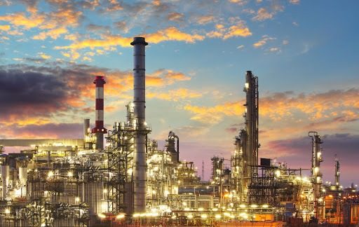Industrial plant with tall processing towers lit at dusk